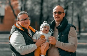 a man and woman holding a baby
